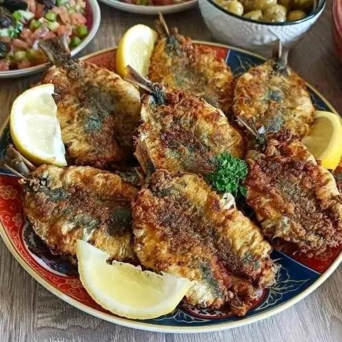 a plate of food with meat and lemon slices at dar elkarzabi in Zagora