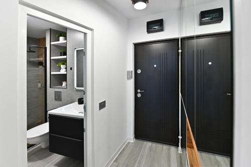 a bathroom with black doors and a white sink at Lili's Studio 2 in Piteşti