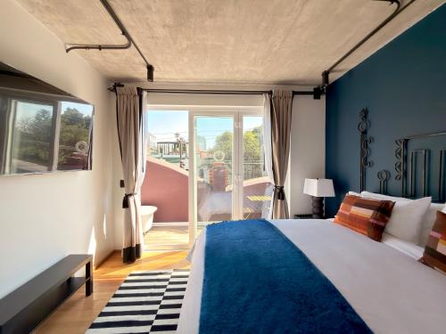 a bedroom with a large bed with blue walls at Maximo Mexico Roma in Mexico City