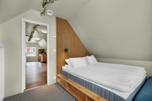 a bedroom with a bed with a wooden headboard at Central Top Floor Apartment in Stavanger