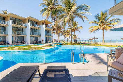 an image of a swimming pool at a resort with palm trees at Kombo Beach Resort in Serekunda