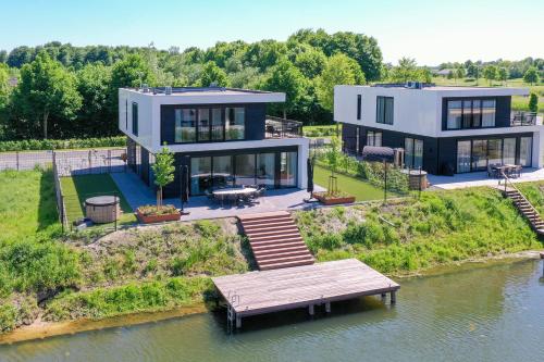 a large house on an island in the water at Maan Nr. 301 | 10 Pers. Hottub in Zeewolde