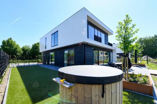 a house with a ping pong table in the yard at Maan Nr. 301 | 10 Pers. Hottub in Zeewolde