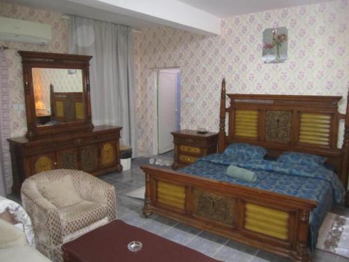 a bedroom with a bed and a chair and a mirror at العين الهيلي مصباح ب 5 in Al Ain