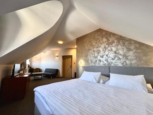a bedroom with a large white bed in a room at Hotel U Vlašského Dvora in Kutná Hora