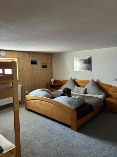 a bedroom with a large bed with a dog on it at Ferienhaus Gertrud in Nesselwängle