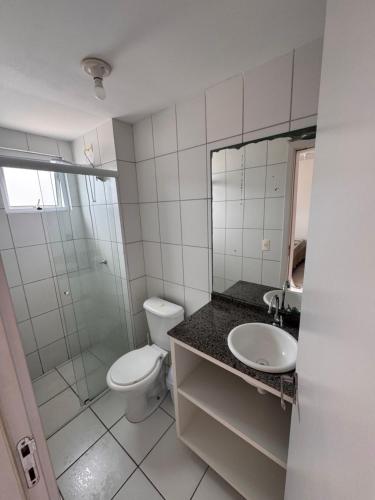 a white bathroom with a toilet and a sink at Apartamento com vista imperdível in Laguna