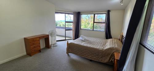 a bedroom with a bed and a dresser and a window at Cagou's Bach in Kuratau
