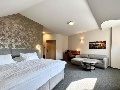 a hotel room with a bed and a couch at Hotel U Vlašského Dvora in Kutná Hora