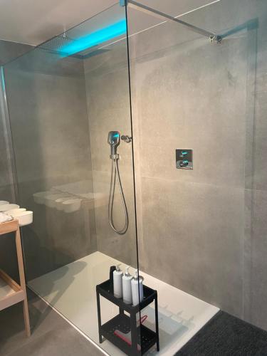 a shower with a blue light in a bathroom at Chez Kri in Limbourg