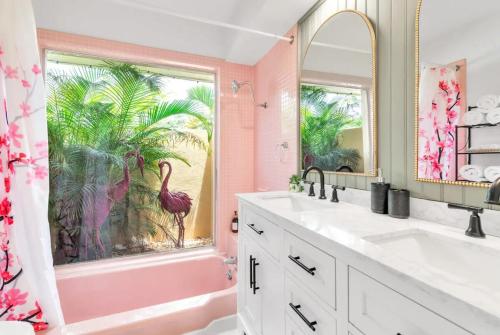 a pink bathroom with a large window with a flamingo mural at Pink Flamingo in Clearwater
