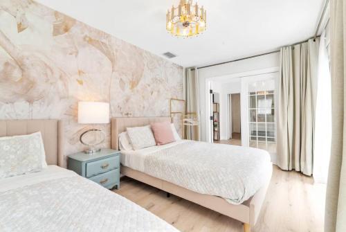a bedroom with two beds and a chandelier at Pink Flamingo in Clearwater