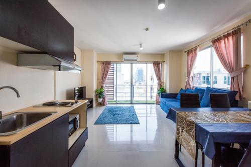 a kitchen and a living room with a blue couch at Amazing 2 bedrooms, near MRT Ratchada, Bangkok in Bangkok