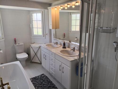 a bathroom with two sinks and a shower and a toilet at Villa Elegante, with a private pool in Murcia