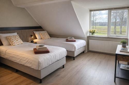 a bedroom with two beds and a window at Hotel de Koningsherberg in Anloo