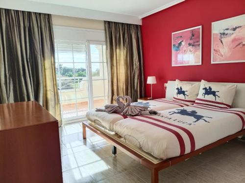 a bedroom with a large bed with a red wall at Villa Elegante, with a private pool in Murcia