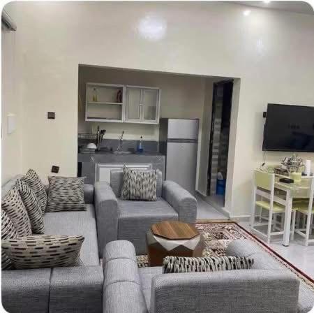 a living room with two couches and a kitchen at ESSERa in Nouakchott