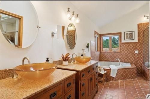 a bathroom with two vessel sinks and a tub at Bayou Hills BnB in Parker