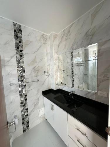 a bathroom with a sink and a mirror at Hotel Cabaleón in Tena