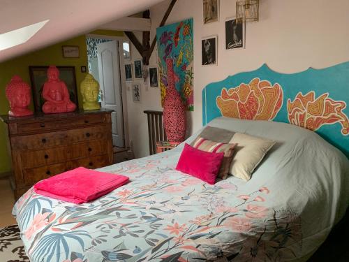 a bedroom with a large bed with pink pillows at Maison de charme du 18 e s de centre ville in Sablé-sur-Sarthe