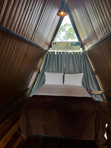 a bed in a metal tent with a window at Refúgio romântico em Pirenópolis Chalé Ypê Branco Ypês da Serra in Pirenópolis