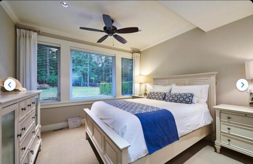 a bedroom with a bed and a ceiling fan at Qualicum Landing Coastal Cottage in Qualicum Beach