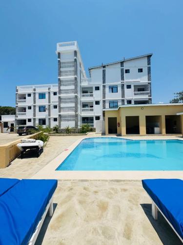 a large swimming pool in front of a building at TajiS Diani Chic 1 BR with swimming pool in Diani Beach