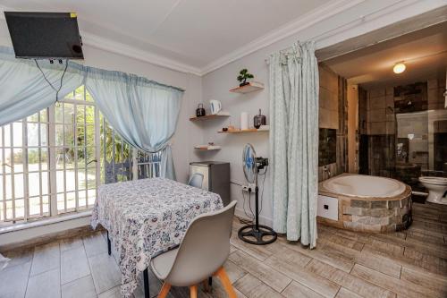 a room with a table and a tub and a television at Phindulo Bed and Breakfast - No Loadshedding, Smart TVs & unlimited free fibre wifi in Krugersdorp