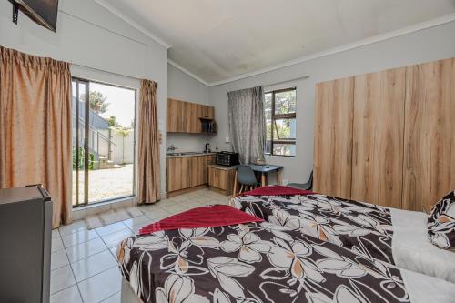 a bedroom with a bed and a kitchen in it at Phindulo Bed and Breakfast - No Loadshedding, Smart TVs & unlimited free fibre wifi in Krugersdorp