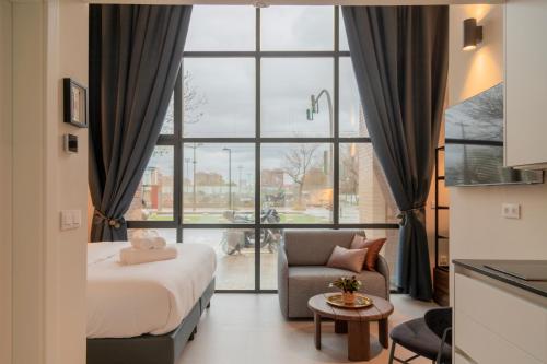 a bedroom with a bed and a chair and a window at ARENA byAstiblanco in Valencia