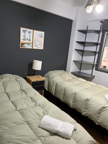 a bedroom with two beds and a book shelf at Peatonal Santafesina in Santa Fe