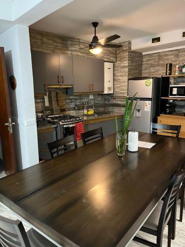 a large wooden table in a kitchen with a counter top at Peatonal Santafesina in Santa Fe