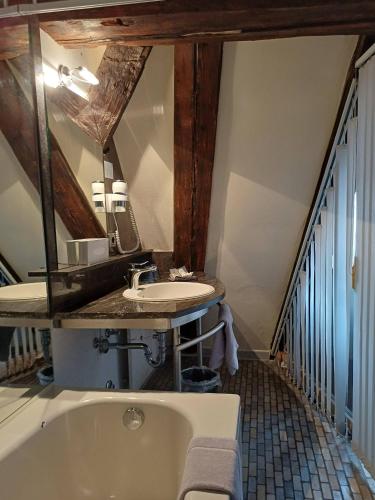 a bathroom with a sink and a bath tub at Schiefes Haus in Ulm