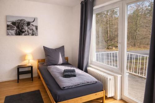 a room with a bed and a large window at Die ANS Group Cozy Apps in Detmold