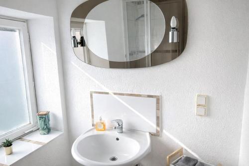 a bathroom with a sink and a mirror on the wall at Die ANS Group Cozy Apps in Detmold