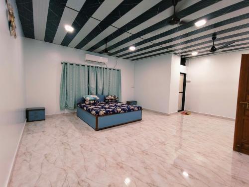 a bedroom with a bed in the middle of a room at Varsha farm house in Guhagar