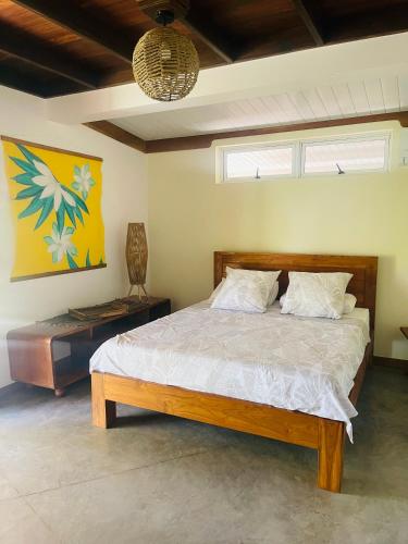 a bedroom with a bed and a painting on the wall at Villa BOUDDHA- Raiatea in Uturoa