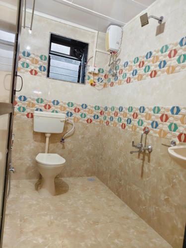 a bathroom with a toilet and a sink at Varsha farm house in Guhagar