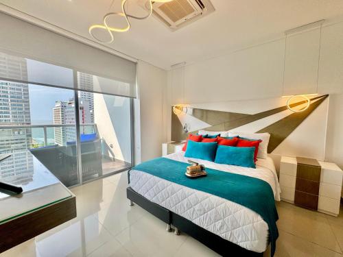 a bedroom with a bed with blue and red pillows at Apartamento Special For You in Cartagena de Indias