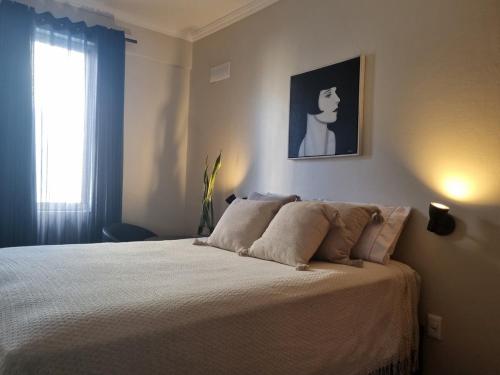 a bedroom with a bed with a picture on the wall at Céu Sol Sul in Porto Alegre