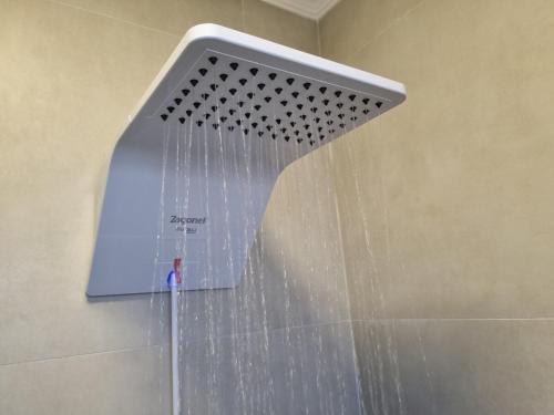 a shower head with water coming out of it at Céu Sol Sul in Porto Alegre
