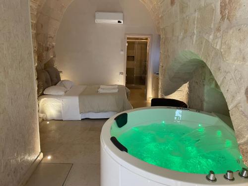 a bathroom with a tub in a room with a bed at Barbacana Monopoli in Monopoli