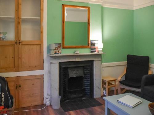 a living room with a fireplace and a mirror at North Cottage in Lowestoft
