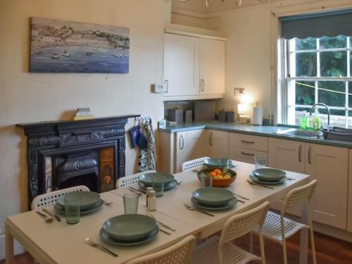 a kitchen with a table with green plates on it at North Cottage in Lowestoft