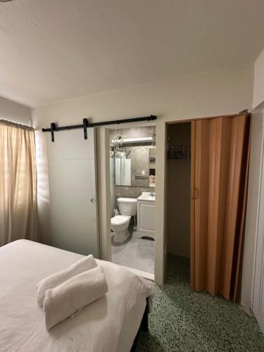 a bedroom with a bed and a bathroom with a toilet at Villa Bamboo in San Juan