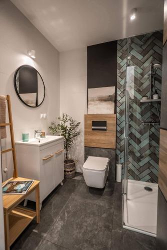 a bathroom with a toilet and a sink and a shower at Lasosfera Lasówka in Lasowka