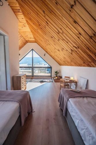 a large room with two beds and a large window at Lasosfera Lasówka in Lasowka