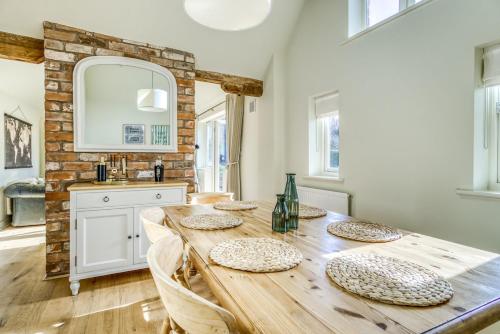 a dining room with a wooden table with chairs at Gleanings Cottage in Bredon