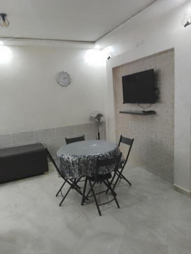 a room with a table and chairs and a tv at Chez Franck in Saïdia