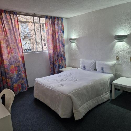 a hotel room with a bed and a window at Hotel polly in Mexico City